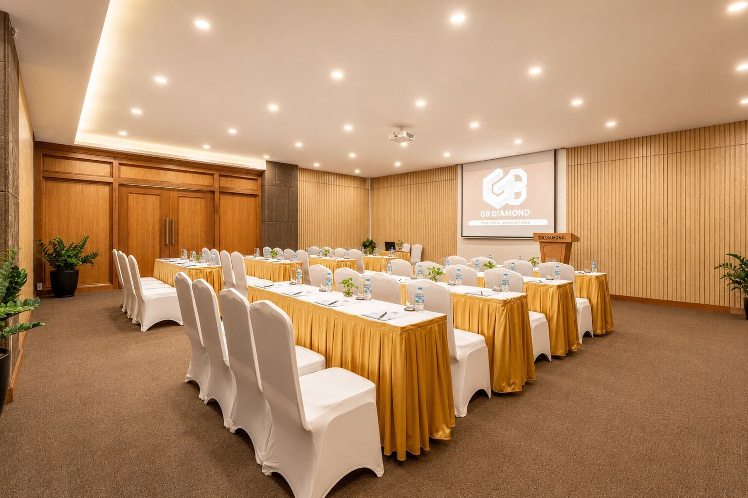 A conference room with multiple tables and chairs, a projector screen, and a podium.