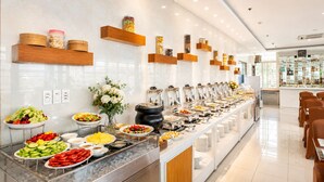 Un buffet proposant divers plats, une composition florale et un bar avec des bouteilles.