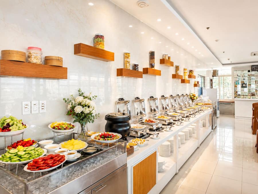 Un bufé con diversas opciones de comida, una decoración floral y una zona de bar con botellas.