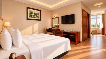 Een hotelkamer met een bed, bureau, stoel, televisie en een groot raam.