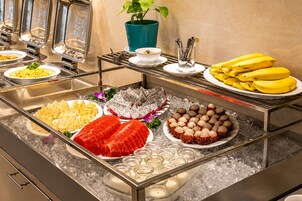 A buffet with various food items, including fruits, seafood, and a plant.