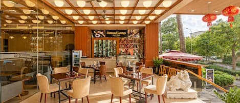Un restaurante moderno con barra, asientos y vistas al exterior.