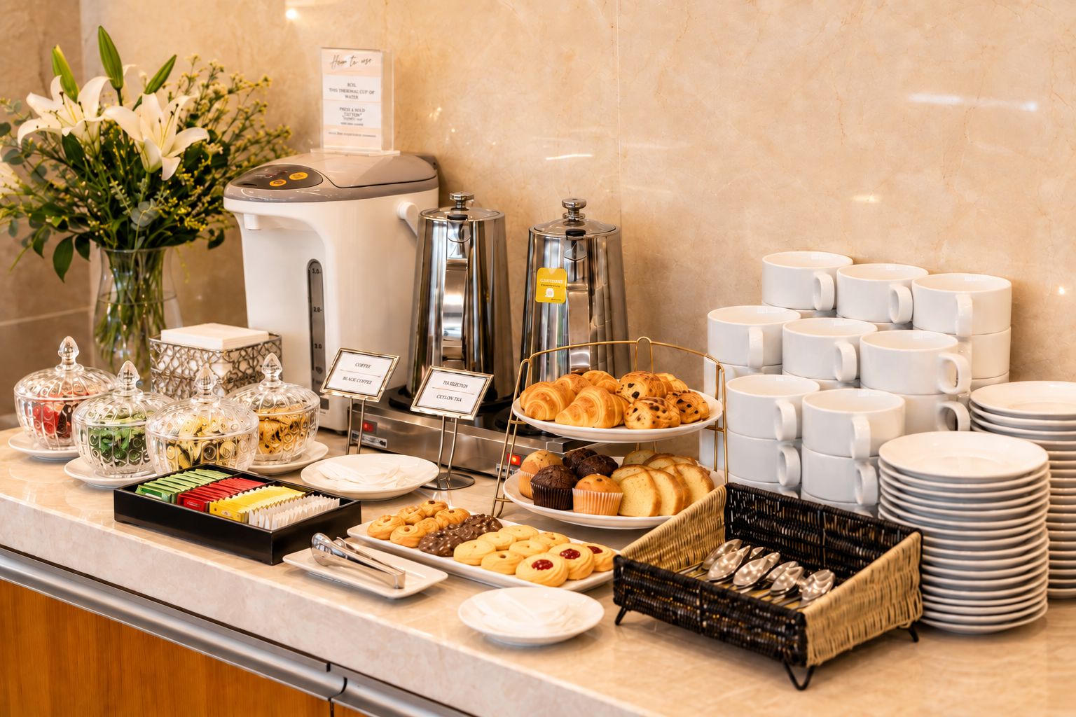 Un buffet proposant une variété de plats, des machines à café et des distributeurs de thé.