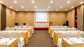 Un salón de conferencias con mesas dispuestas para una reunión, un atril y una pantalla que muestra 'G8 DIAMOND'.