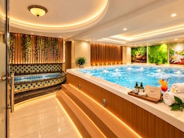 A spa area with a hot tub, wooden paneling, a tiled wall, and a welcome sign.