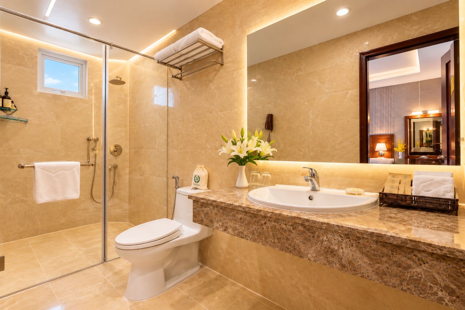 Un baño moderno con ducha envuelta en vidrio, inodoro blanco, encimera de mármol, lavabo y un espejo grande.