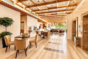 A modern hotel lobby with a wooden ceiling, a reception desk, seating area, and potted plants. - G8 Diamond Hotel Saigon (Ho Chi Minh City)