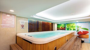 Une piscine intérieure moderne avec un revêtement mural en bois, un éclairage au plafond et des affiches informatives accrochées aux murs.