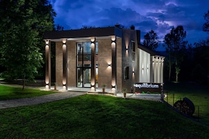 A modern building with a glass facade, illuminated by exterior lights, and a sign reading 'equilibrium.'