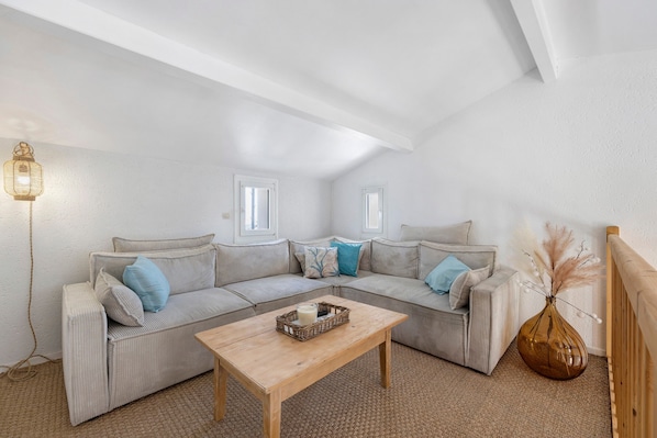 A living room with a sofa, a coffee table, a lamp, and a vase.