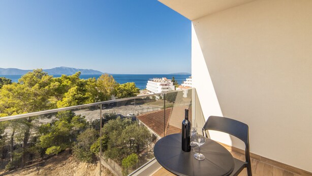 A balcony with a table, a chair, a bottle, and a glass. - Altiora Prestige Residence 302 (Gradac)