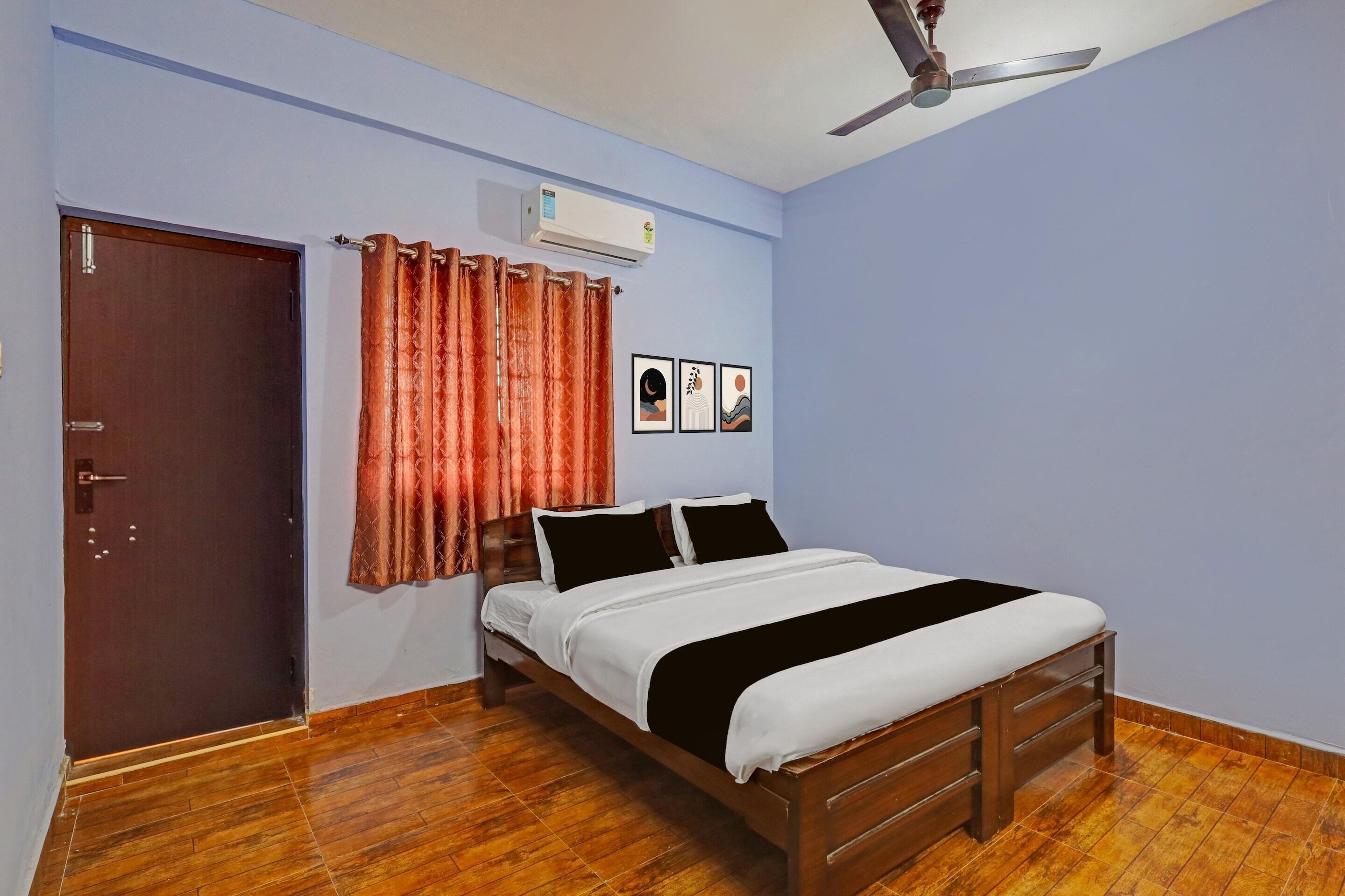 A bedroom with a bed, a ceiling fan, an air conditioner, a door, and a curtain.