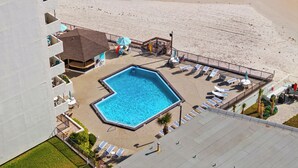 A rooftop pool with a view of the beach, lounge chairs, and a small building with a roof. - Enjoy stunning ocean views from the balcony, living room, dining area, and kitchen. This 2BR condo features a heated beachfront pool, fitness room, king beds in both bedrooms, and comfortably sleeps 4 in beautiful Daytona Shores. (Daytona Shores)