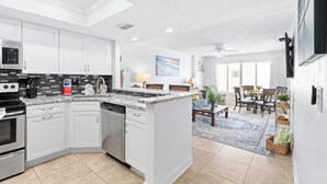 A modern kitchen with white cabinets, a granite countertop, and a dishwasher. - Enjoy stunning ocean views from the balcony, living room, dining area, and kitchen. This 2BR condo features a heated beachfront pool, fitness room, king beds in both bedrooms, and comfortably sleeps 4 in beautiful Daytona Shores. (Daytona Shores)