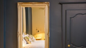 Un dormitorio con cama, almohadas, mesita de noche y lámpara.
