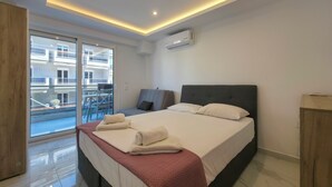 Et moderne hotelværelse med en stor seng, en balkon og et klimaanlæg.