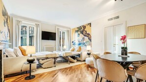 A modern living room with a sofa, coffee table, and dining area with chairs. - "Airbnb Luxe" Gorgeous + 3 Bedroom Near The Duomo (Milano)