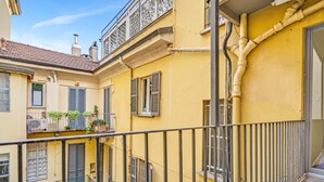 A yellow building with balconies, a metal railing, and a staircase. - "Airbnb Luxe" Gorgeous + 3 Bedroom Near The Duomo (Milano)