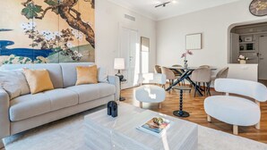 A modern living room with a sofa, coffee table, and a dining area with chairs and a table. - "Airbnb Luxe" Gorgeous + 3 Bedroom Near The Duomo (Milano)