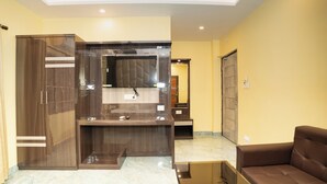 A modern interior with a reception desk, a mirror, and a brown sofa. - Mahabhoj Hotel & Restaurant (Mandarmani)