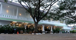 Un hôtel doté d’un espace extérieur abrité, de colonnes et d’un grand arbre.