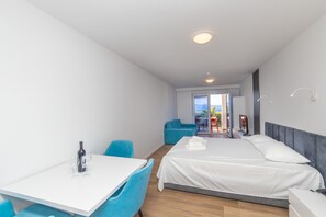 A hotel room with a bed, a table, and a chair. There is a window with a view of the outside. - Altiora Prestige Residence 303 (Gradac)