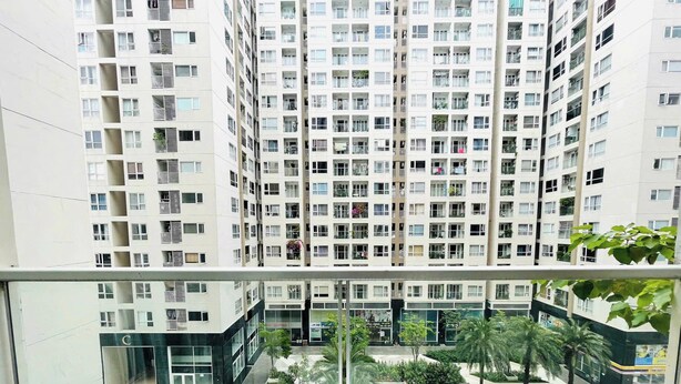 A high-rise residential building with multiple balconies, a swimming pool, and surrounding greenery. - Luxury 2 bedroom Apartment Sky Center (Ho Chi Minh City)