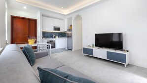 A modern living room with a sofa, a television, and a kitchen in the background. - CASA APREDA (Sorrento)
