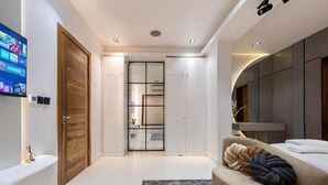 A modern bedroom with a bed, a TV, a wardrobe, and a bathroom. - Primehomes  (Lekki)