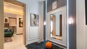 A modern interior with a large mirror, artwork, and a plush rug. - Primehomes  (Lekki)