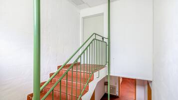 A staircase with green railings and terracotta steps.