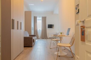 Escritorio, cortinas blackout y tabla de planchar con plancha