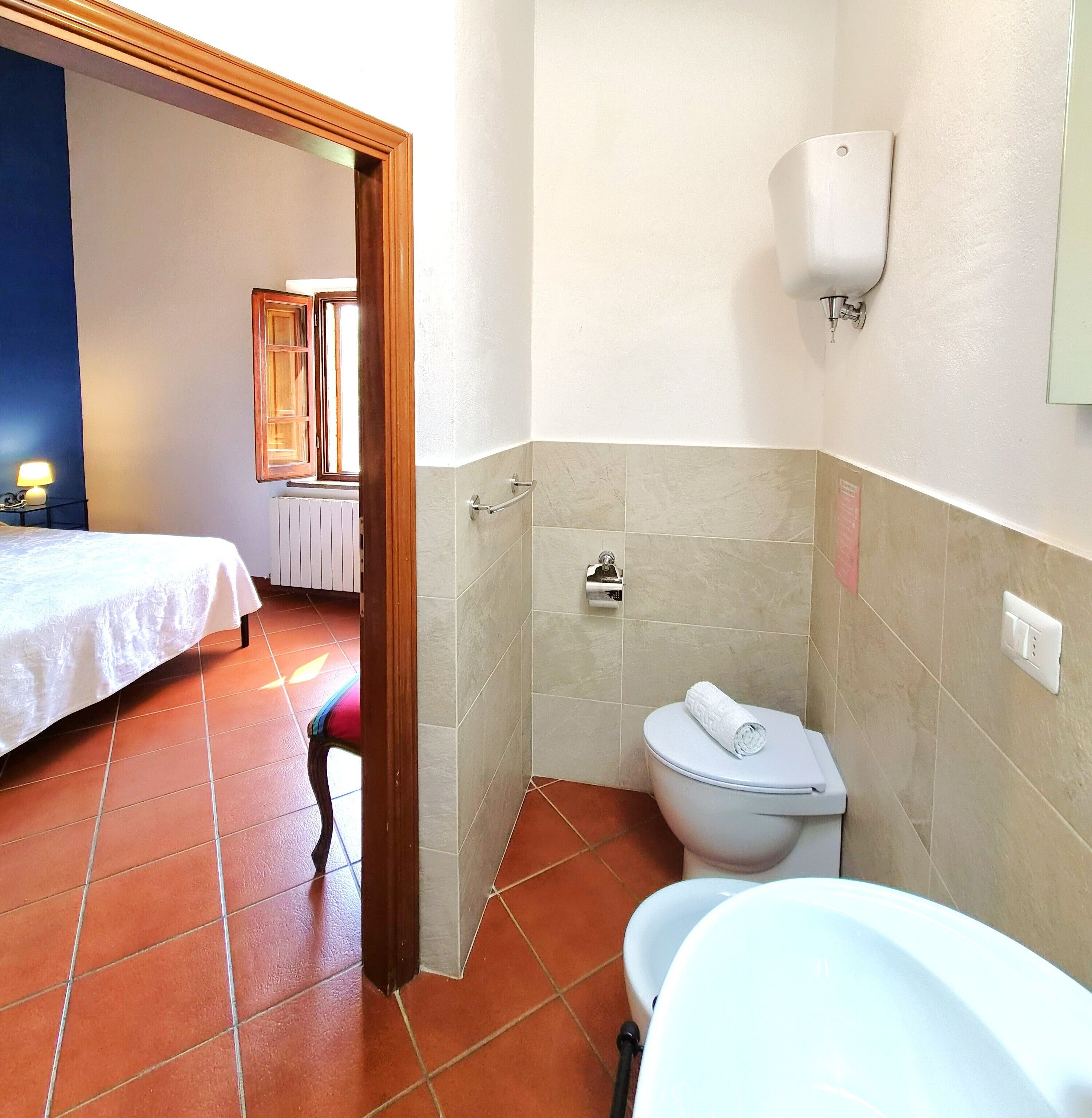 Une salle de bain équipée de toilettes, d’un sèche-mains et d’un distributeur de serviettes.