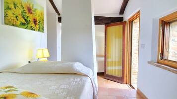 Una camera da letto con un letto, un dipinto di girasoli, una lampada e vista sull'esterno.