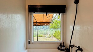 A bathtub with a view of a garden and a window.