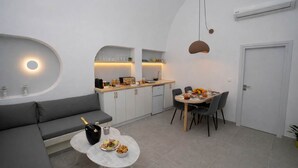 Un espacio habitable compacto con kitchenette, comedor y zona de estar.