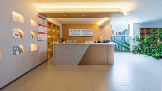 A modern reception area with a reception desk, wall-mounted informational posters, and a view of a cityscape through large windows. - hocoshulvjiudian (Beijing)