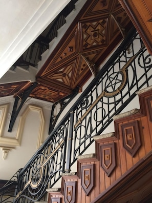 A staircase with ornate metal railings and geometric wooden paneling. - Charming apartment in Sartène, South Corsica, terrace with panoramic view (Sartène)