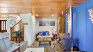A living room with a sofa, coffee table, and a fireplace. - Apartment “La Poya” with Private Terrace, Garden, and Wi-Fi (Plonévez-du-Faou)