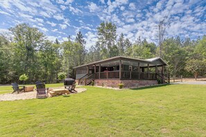 Eine Lodge mit überdachter Terrasse, Sitzgelegenheiten im Freien und einem Feuerkorb.