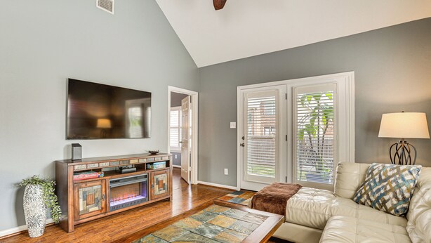 A living room with a flat-screen TV, a fireplace, a sofa, and a coffee table.