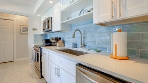 A modern kitchen with white cabinetry, a stainless steel sink, and a dishwasher. - Home w/ Views & Dock on Lemon Bay Aquatic Preserve (Englewood)