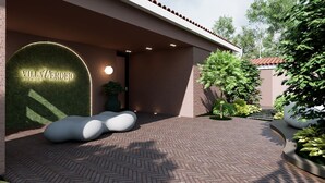 A building entrance with a sign reading 'Villa Verdejo Sitges,' a paved pathway, and a small tree. - Villa Verdejo (Olivella)