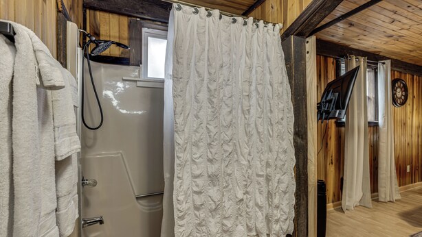 A bathroom with a bathtub, a shower, and a curtain. - Great for Groups! Spacious Melcroft Home w/ Deck (Melcroft)