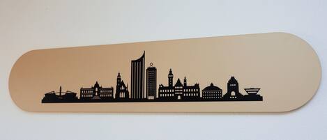 A skateboard with a silhouette of a city skyline.
