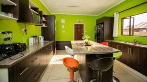 Une cuisine dotée d’un îlot central, de meubles de rangement en bois foncé, d’un ventilateur de plafond et d’une fenêtre offrant une belle vue.