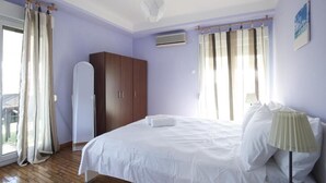 A bedroom with a bed, a wardrobe, a mirror, and a window with curtains. - Ano Patisia A Fully Renovated Penthouse (Athens)