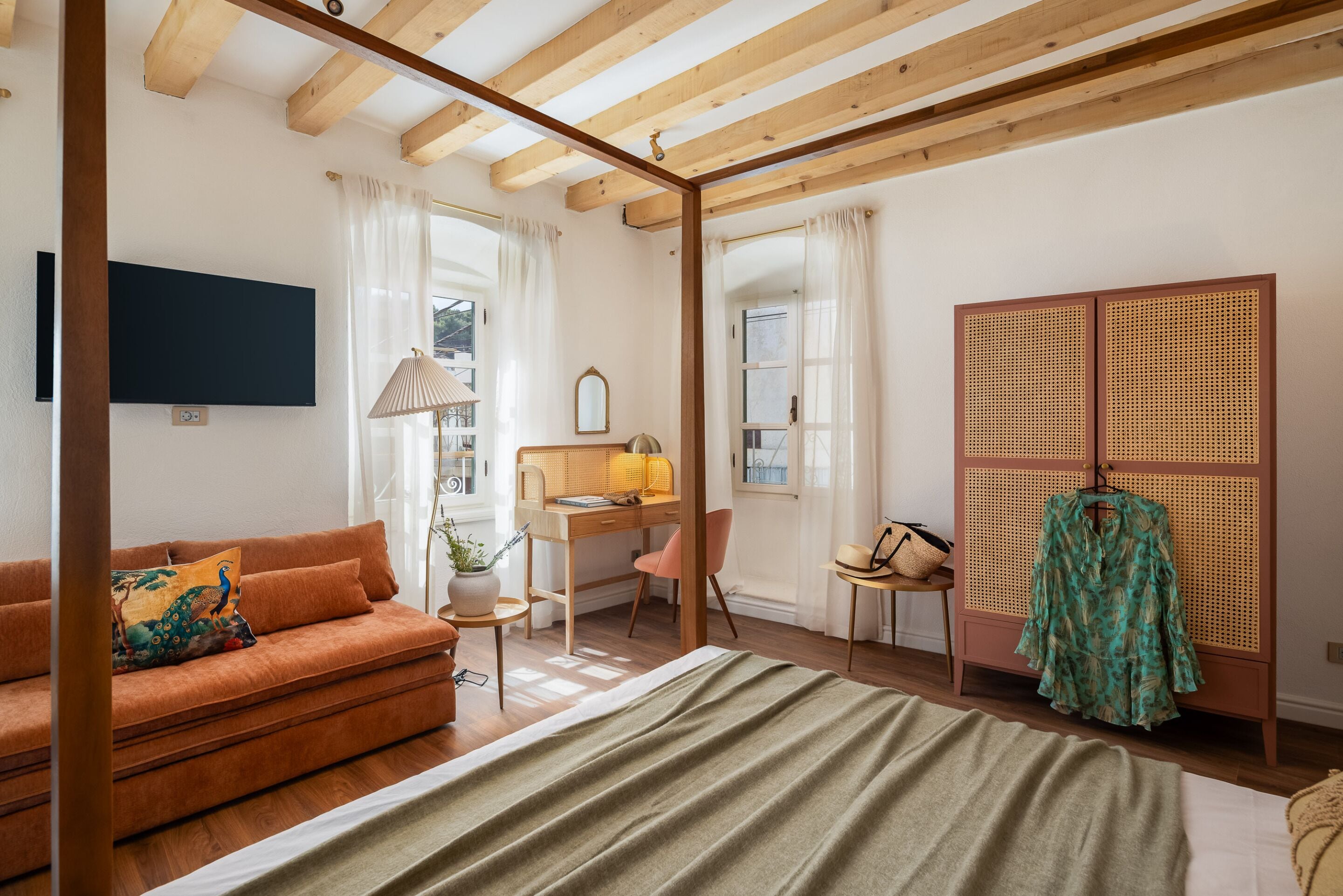 Une pièce comprenant un lit, un bureau, un canapé et une armoire.