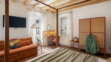 Une pièce comprenant un lit, un bureau, un canapé et une armoire.