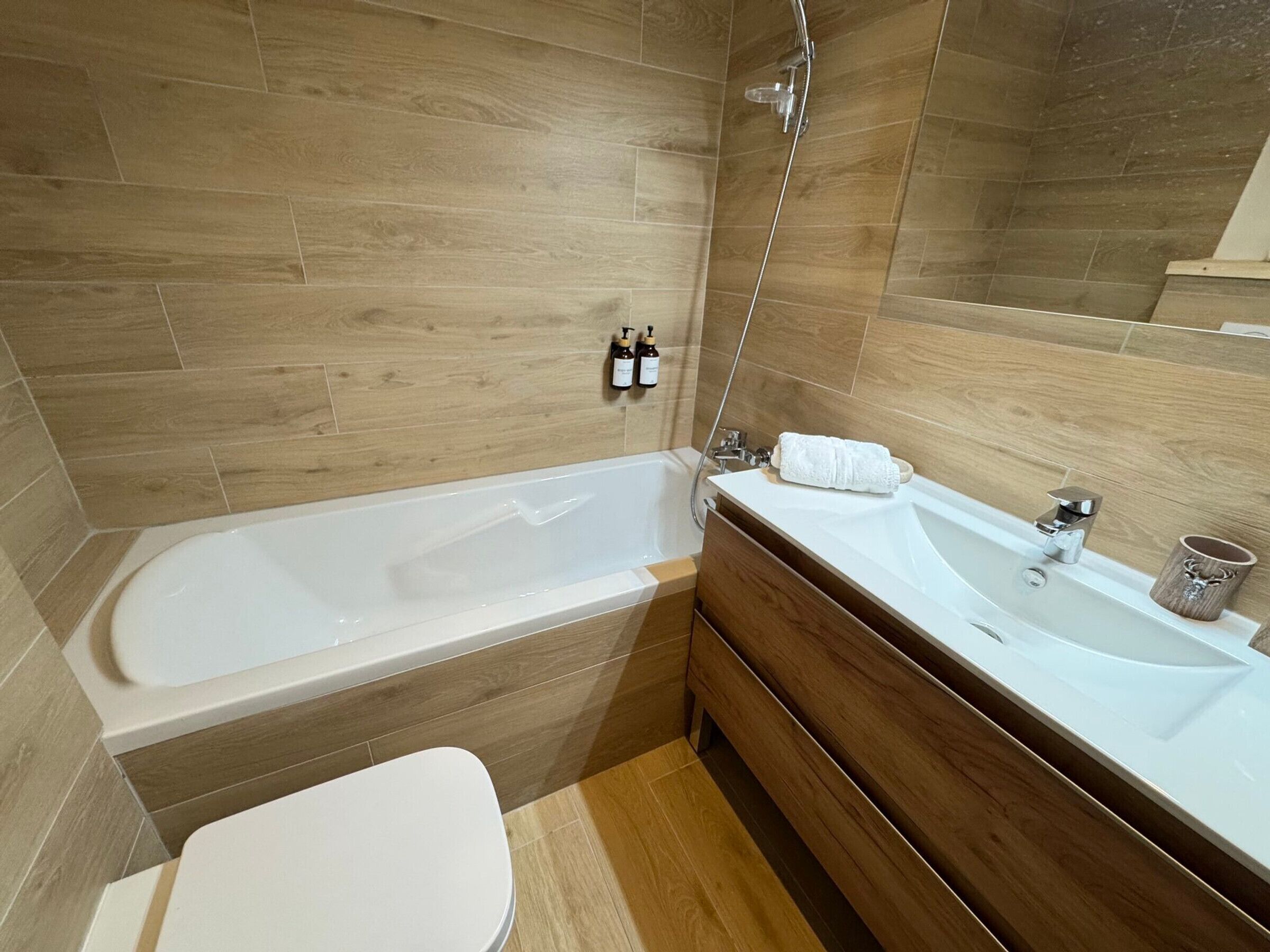 Une salle de bain avec une baignoire, des toilettes, un lavabo et un miroir.